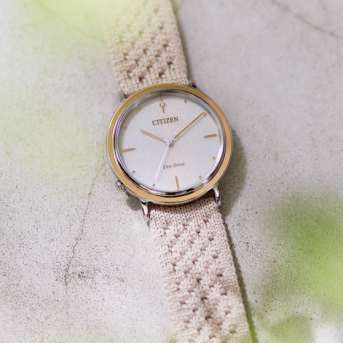 Citizen watch with a cream-colored band on a textured surface