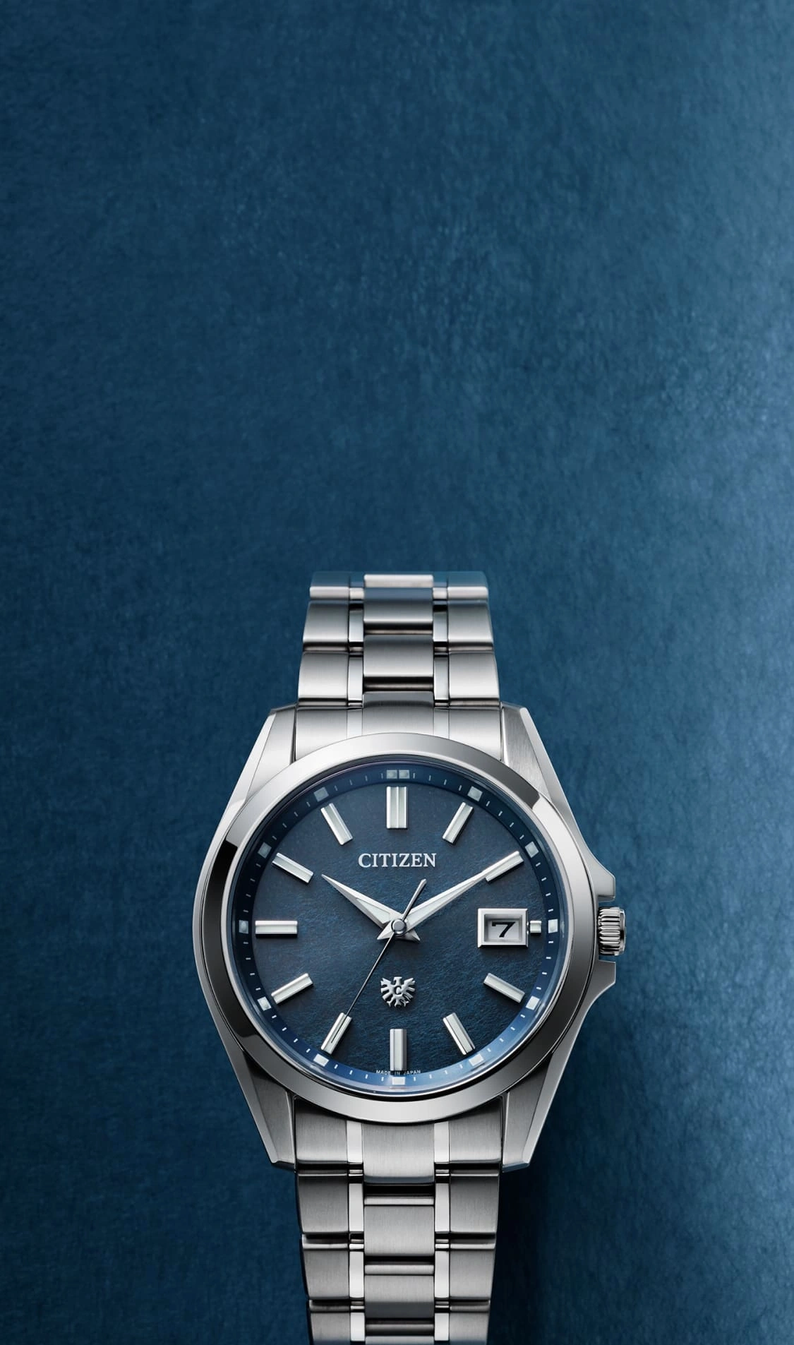Citizen watch with a blue face and silver band on a blue background.
