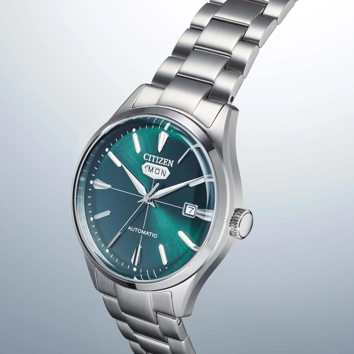 A close-up shot of a Citizen automatic watch with a green dial and silver band.