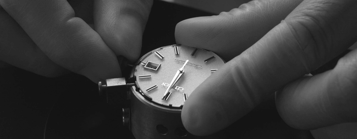Uhr wird montiert, Hände halten die Uhr, Nahaufnahme, Schwarzweiß.