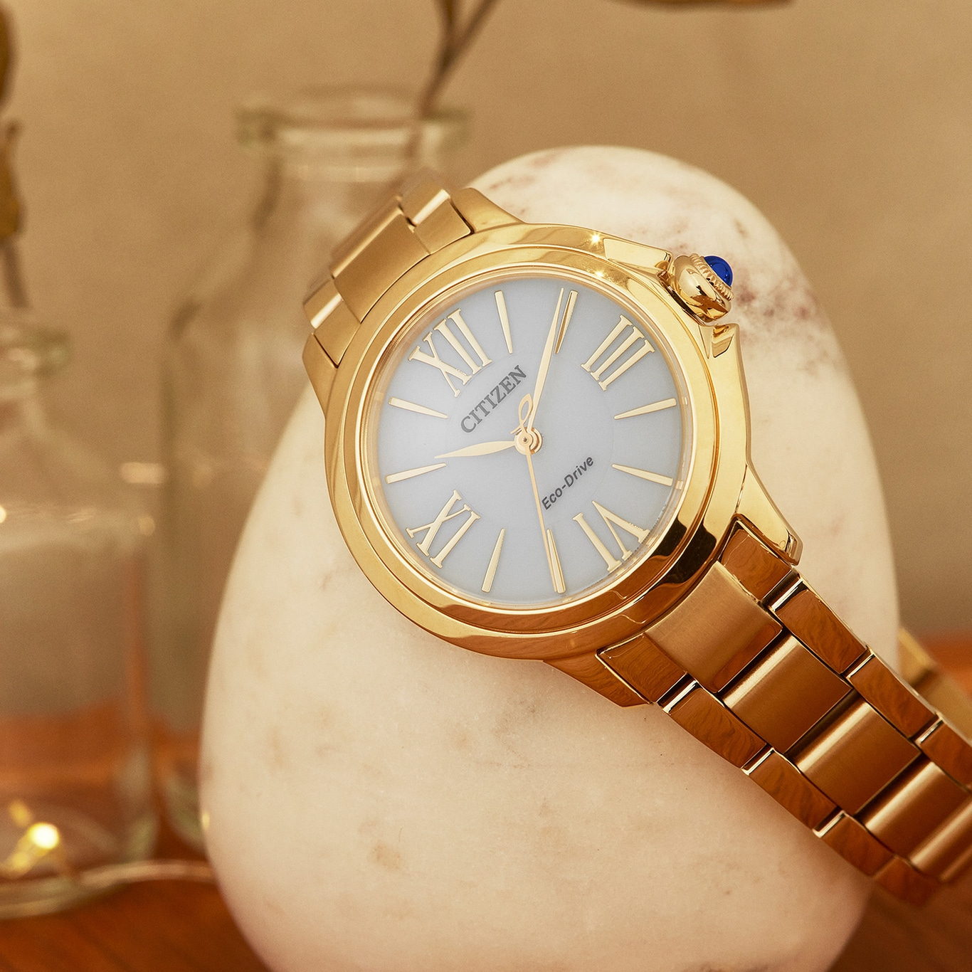 Gold Citizen watch with a light blue face on a white stone
