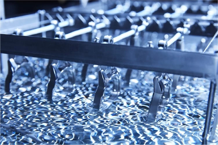 Metal parts being dipped in a liquid, industrial process, close-up shot.
