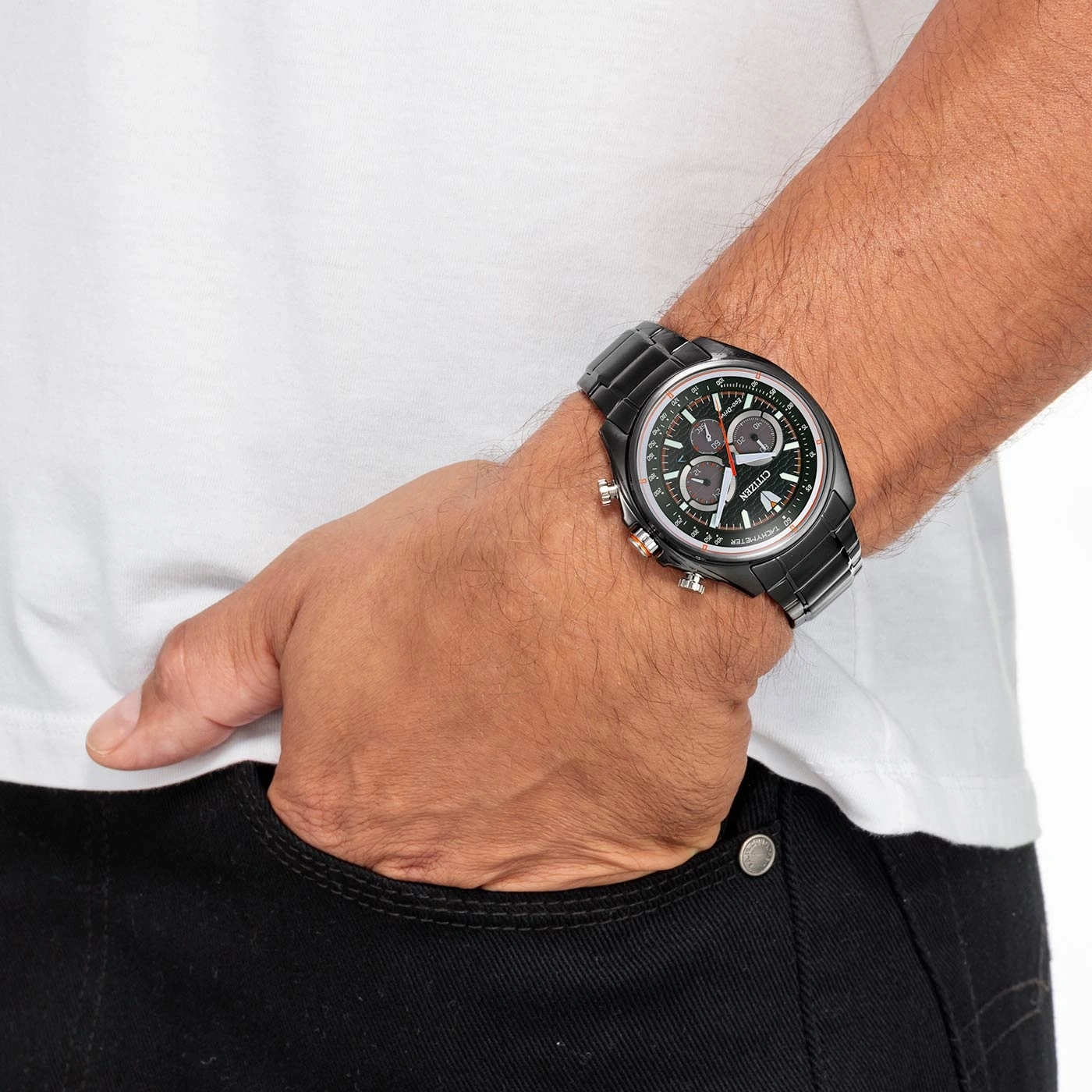 Man wearing a black Citizen watch, hand in pocket, white shirt, black jeans.