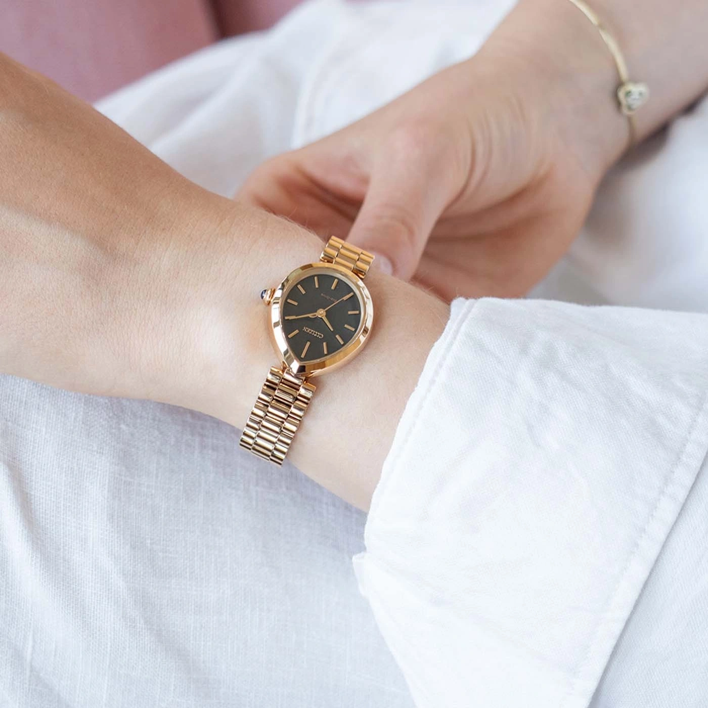 A woman's wrist wears a gold Citizen watch and bracelet.