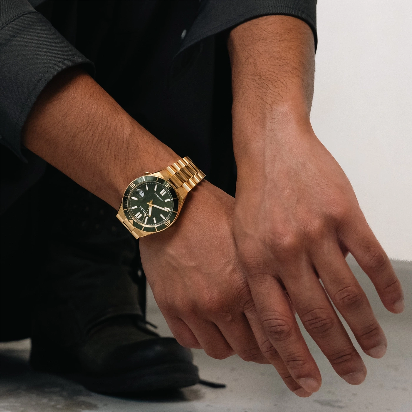 Man wearing a gold watch on his wrist, close-up shot.