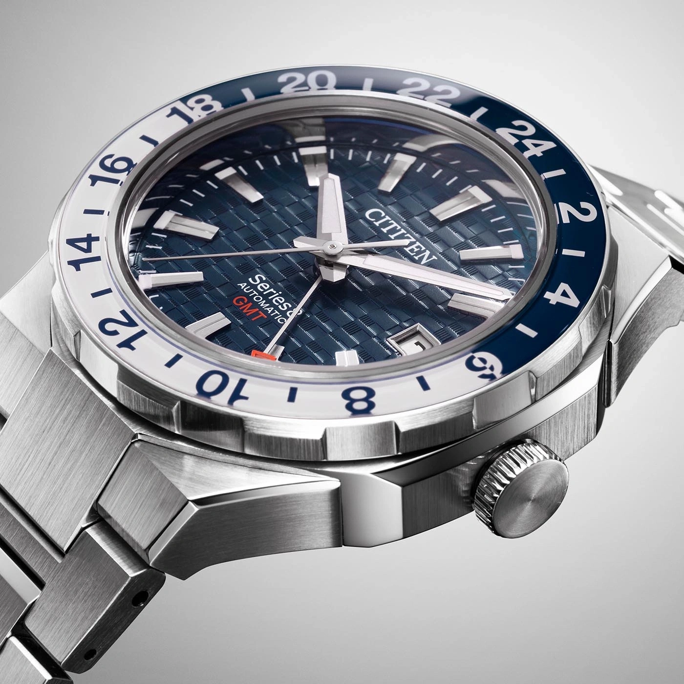 Close-up of a Citizen watch with a blue and white bezel and a metal strap.