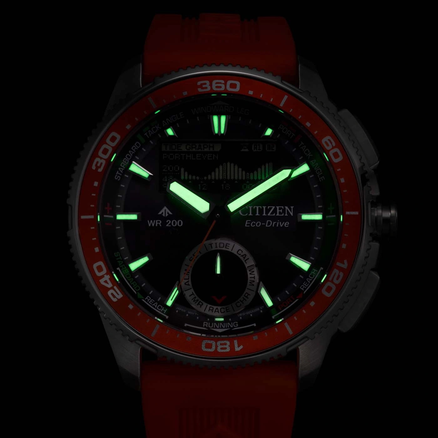 Close-up of a glowing Citizen Eco-Drive watch with a red band and bezel, showing tide graph and other details.