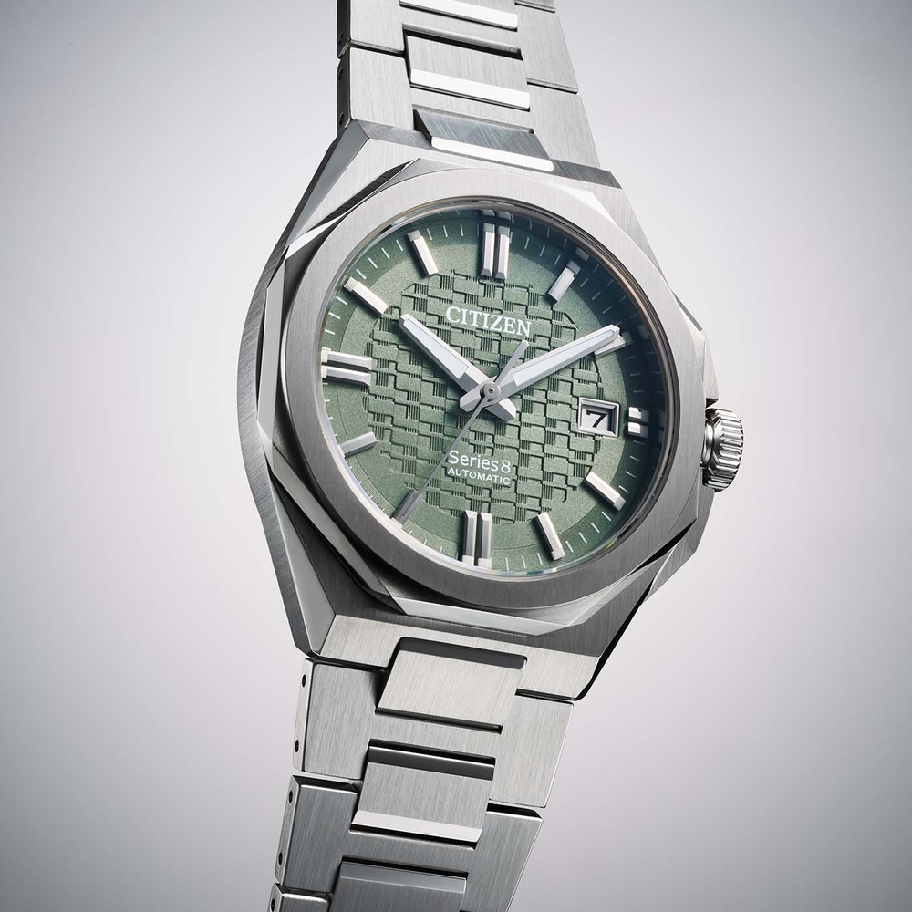 A close-up studio shot of a Citizen Series 8 automatic watch with a green textured dial and stainless steel bracelet.