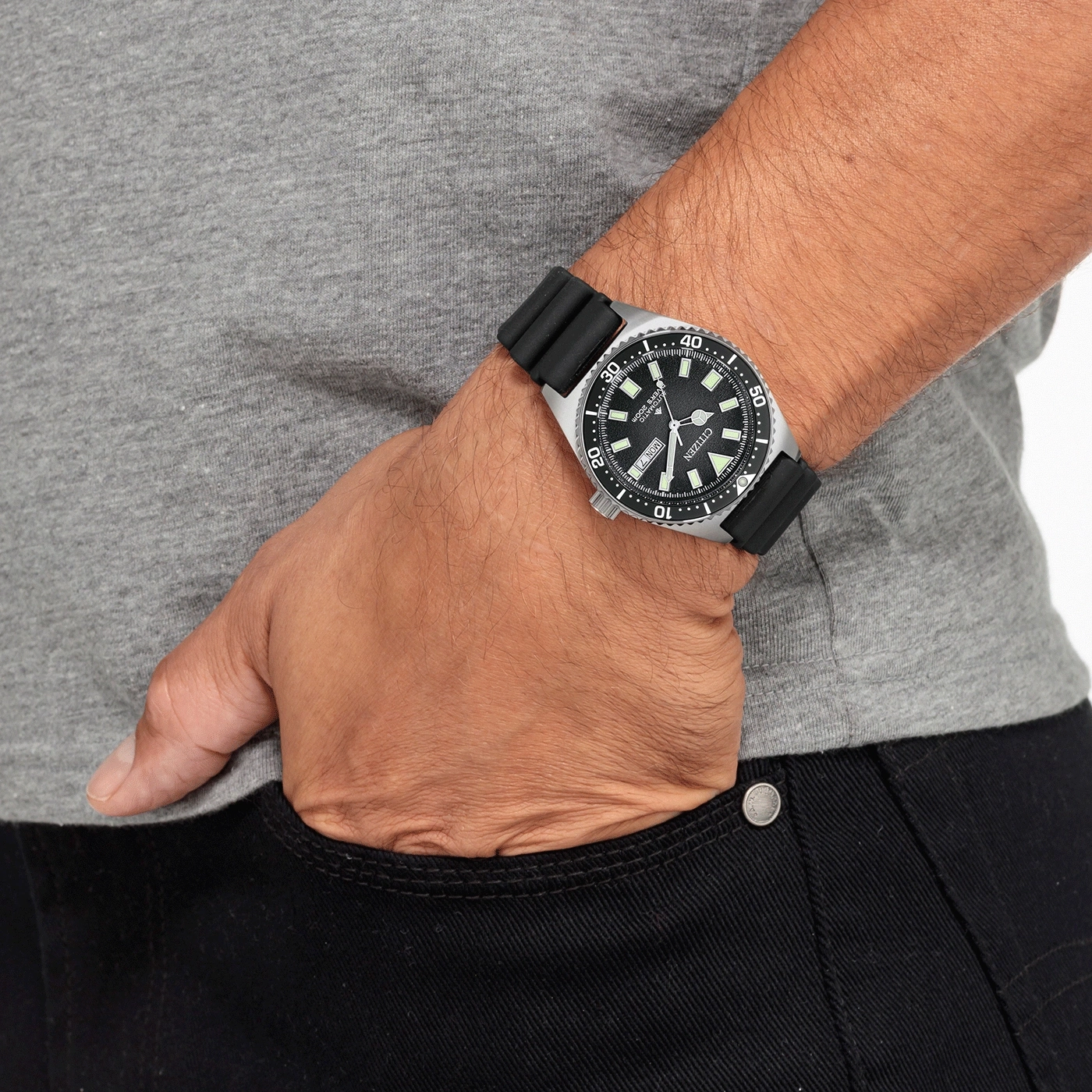Man wearing a Citizen watch with a black strap, hand in pocket.
