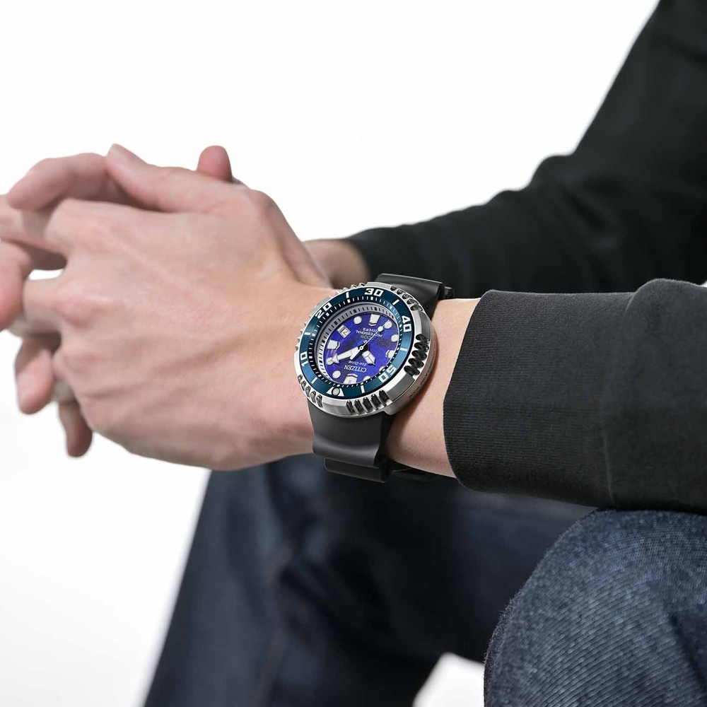 Man wearing a Citizen watch with a blue face and black strap.
