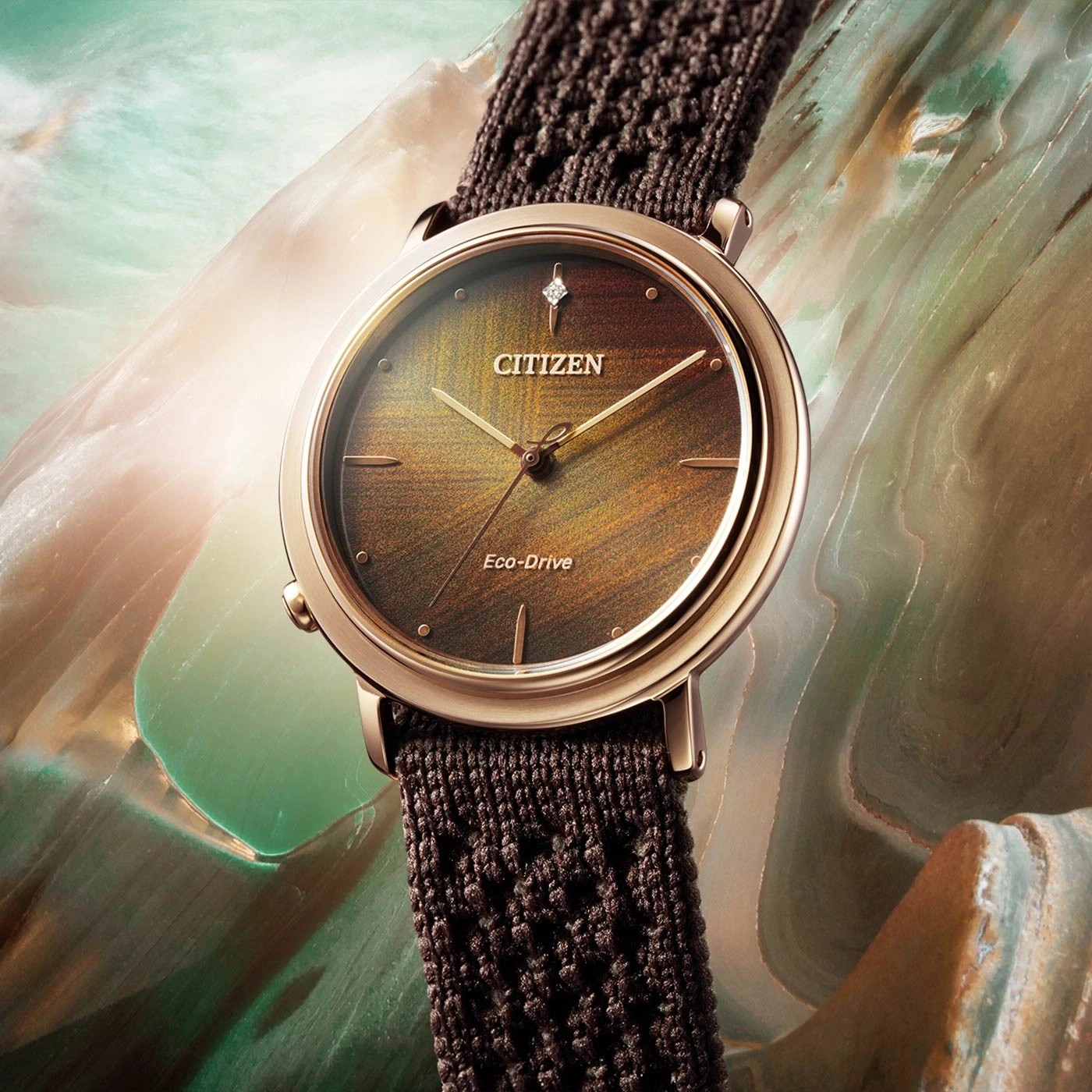 Citizen watch with a brown strap and a golden watch face.