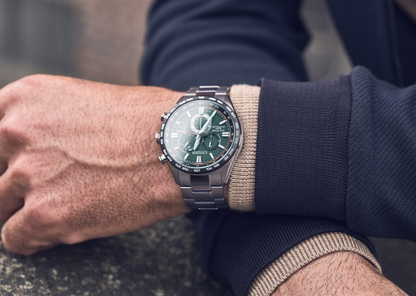 Man wearing a Citizen watch with a green face and silver band.