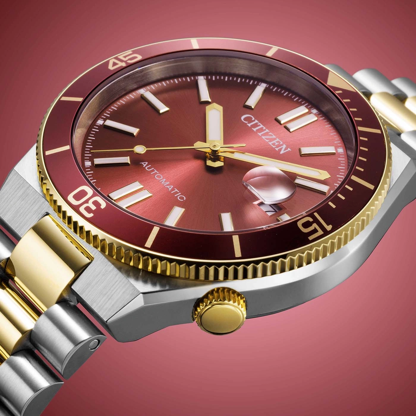 Close-up of a Citizen automatic watch with a red dial and gold accents.
