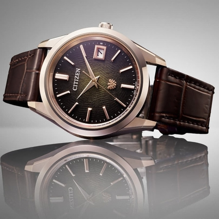 Citizen-Uhr mit dunklem Zifferblatt und braunem Lederarmband, elegantes Design.