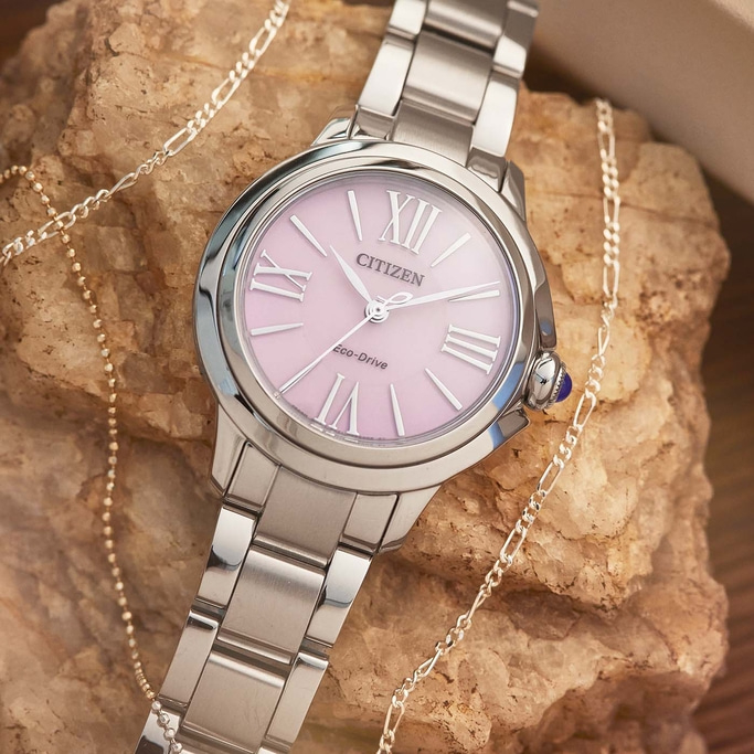 Citizen watch with pink face and silver bracelet, with a necklace.