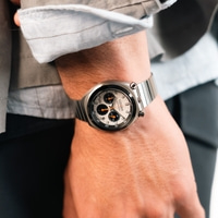 A man wearing a silver Citizen chronograph watch.