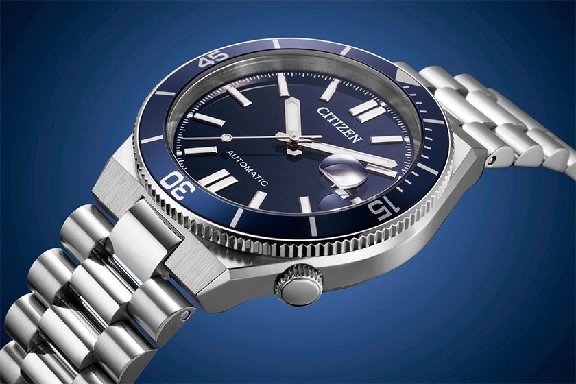A close-up shot of a Citizen automatic watch with a blue dial and silver band.