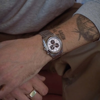 A man's wrist with a watch and a ring.