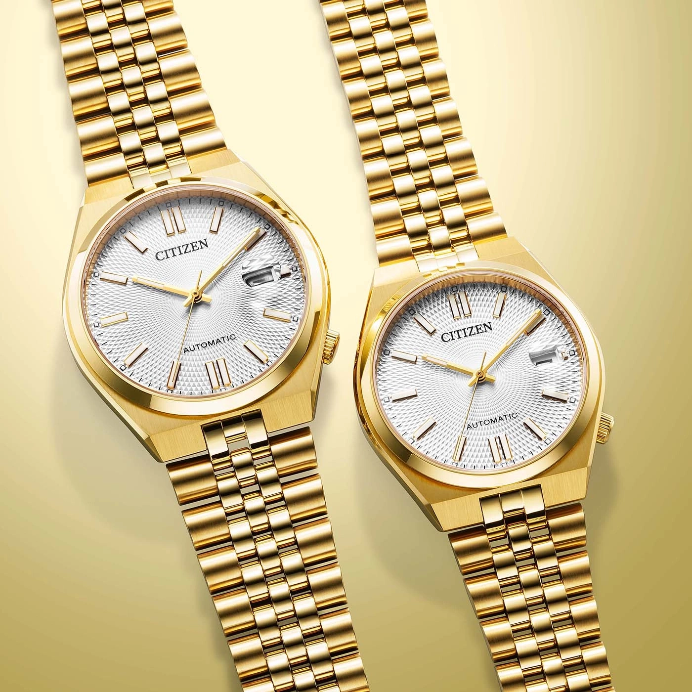 Two gold Citizen automatic watches with white textured dials on a gold background.