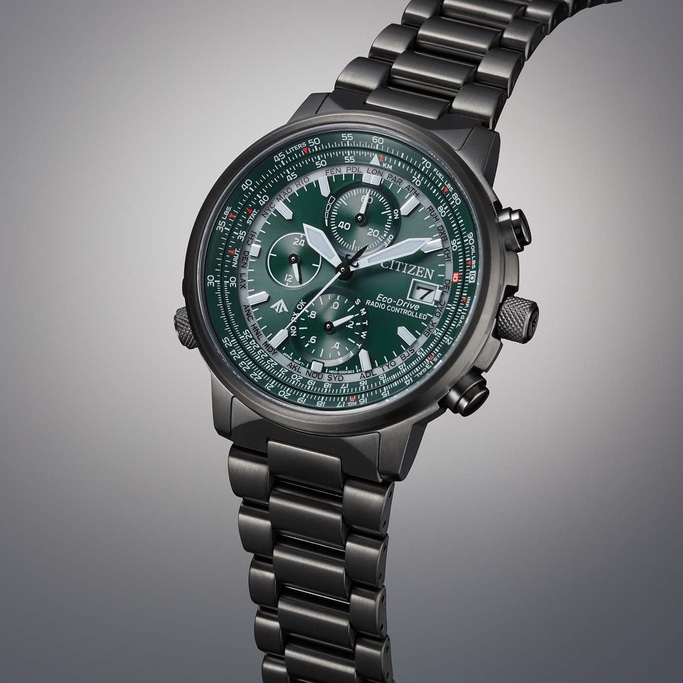 Citizen watch with green face and metal band, angled shot, close-up.