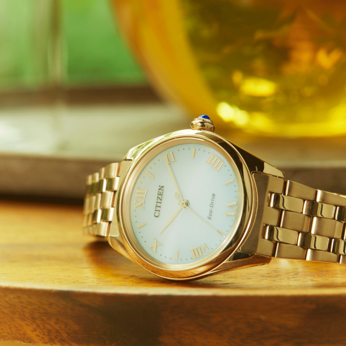 Gold Citizen watch on a wooden surface, close-up shot, elegant design.