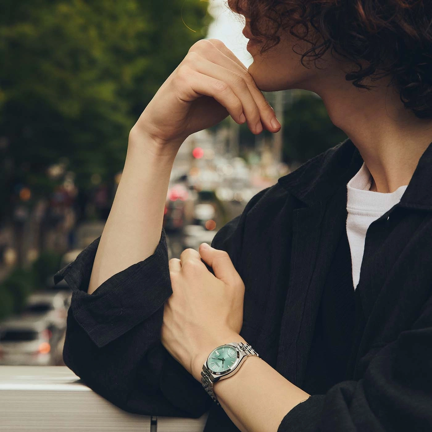 Man wearing a watch, looking thoughtful.