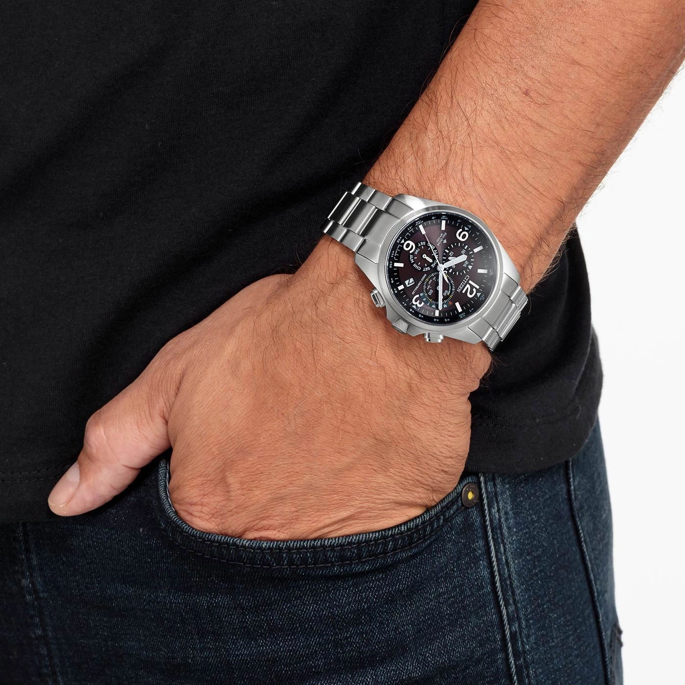 Man wearing a silver watch, black shirt, and blue jeans.