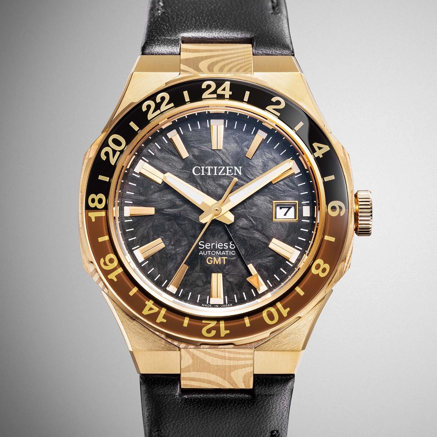 A gold Citizen Series8 Automatic GMT watch with a black dial and black leather strap.