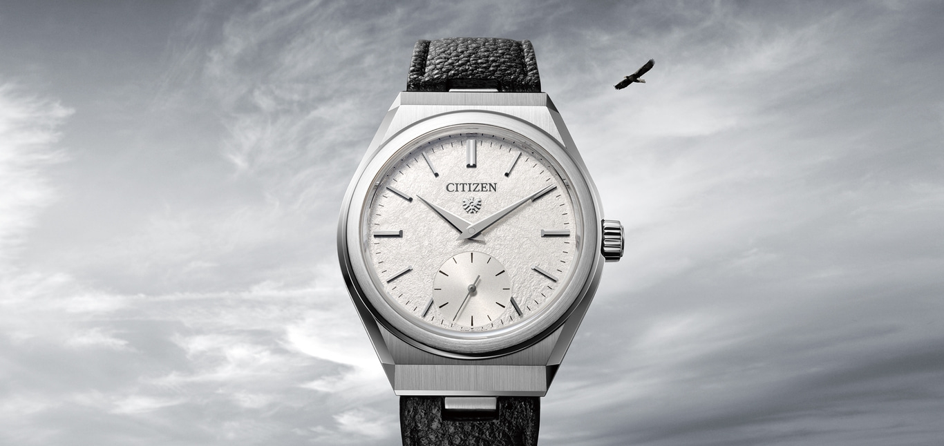 Citizen watch with a textured face and a bird flying in the sky.