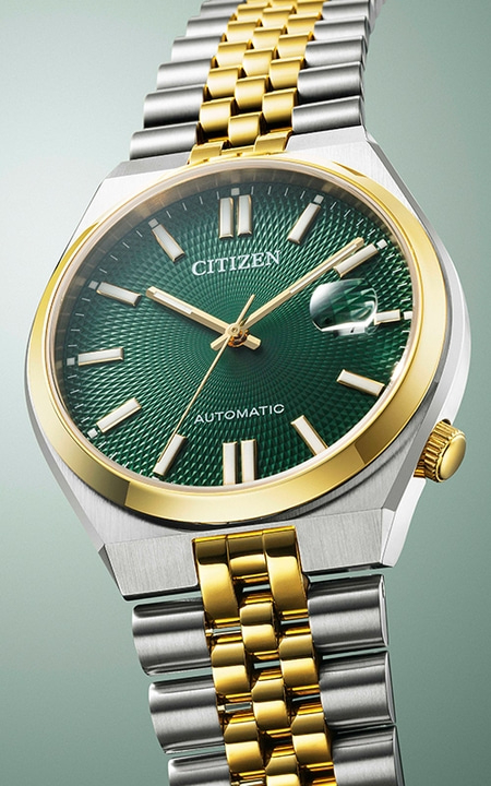 Citizen watch with green face and gold accents, automatic movement, stainless steel band.