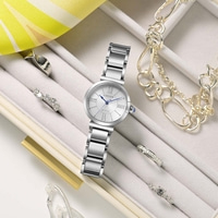 A silver Citizen Eco-Drive watch with rings and bracelets in a jewelry box.