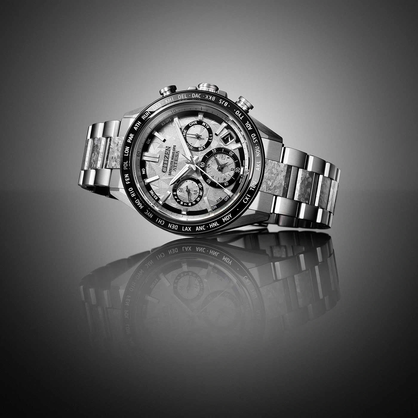 A sleek, modern Citizen watch with a metallic band and intricate dial, reflected on a glossy surface.