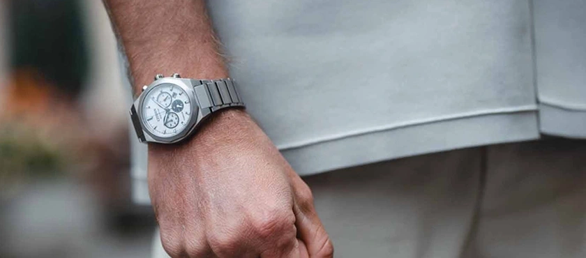Man's wrist wearing a silver chronograph watch