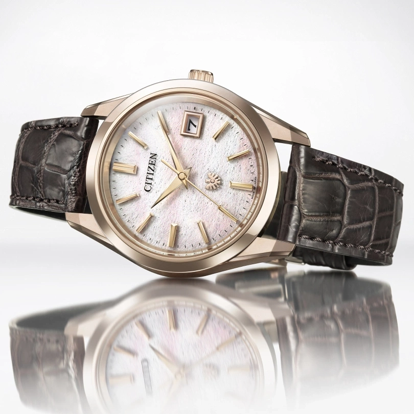 Citizen watch with a white face and a brown leather strap, elegant design.