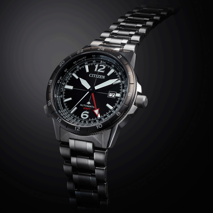Citizen watch with black face, GMT, automatic, stainless steel band, and date display.
