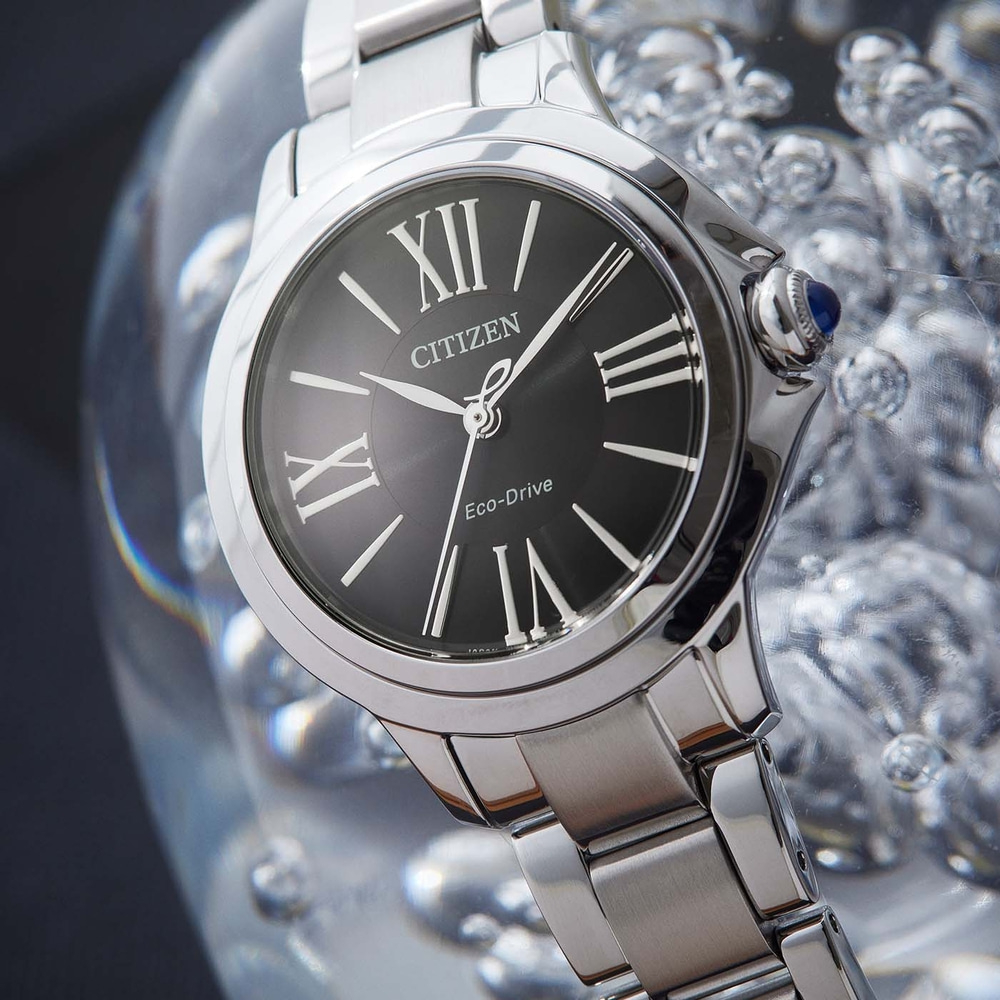 Citizen watch with black face and silver band, close-up shot.