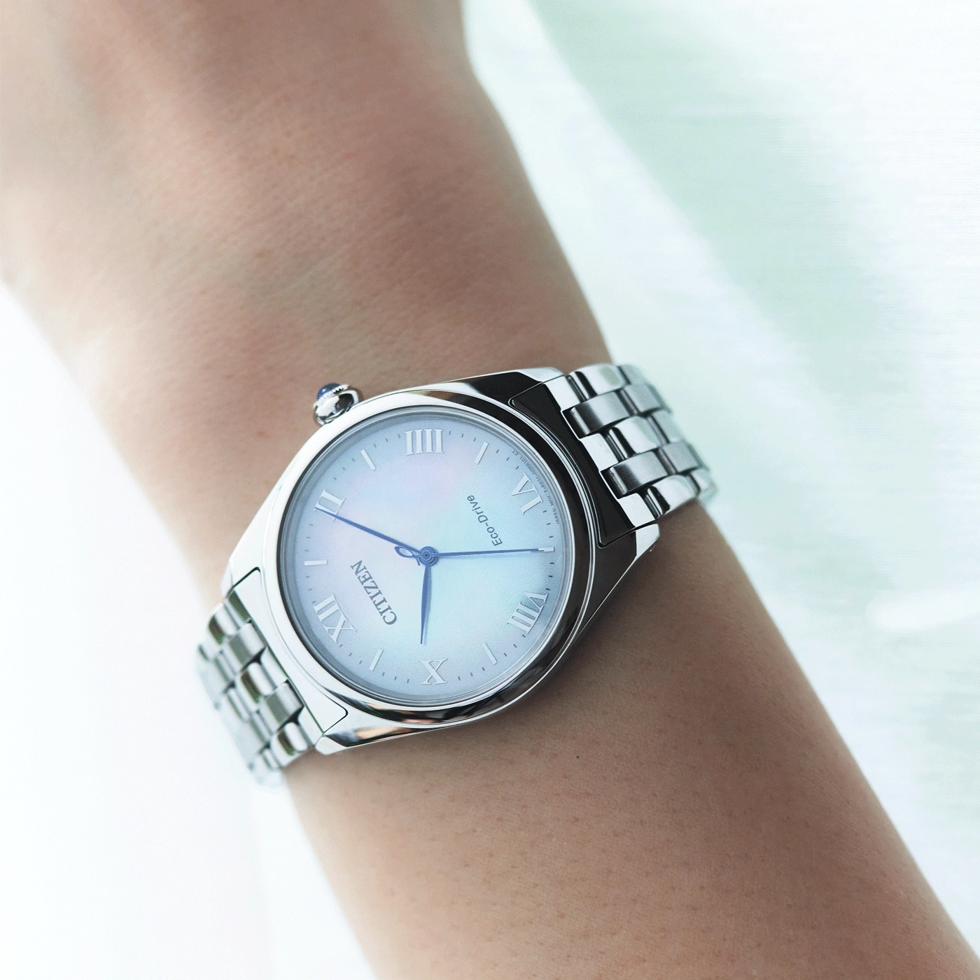 Citizen watch on wrist, silver bracelet, white face, Roman numerals, Eco-Drive