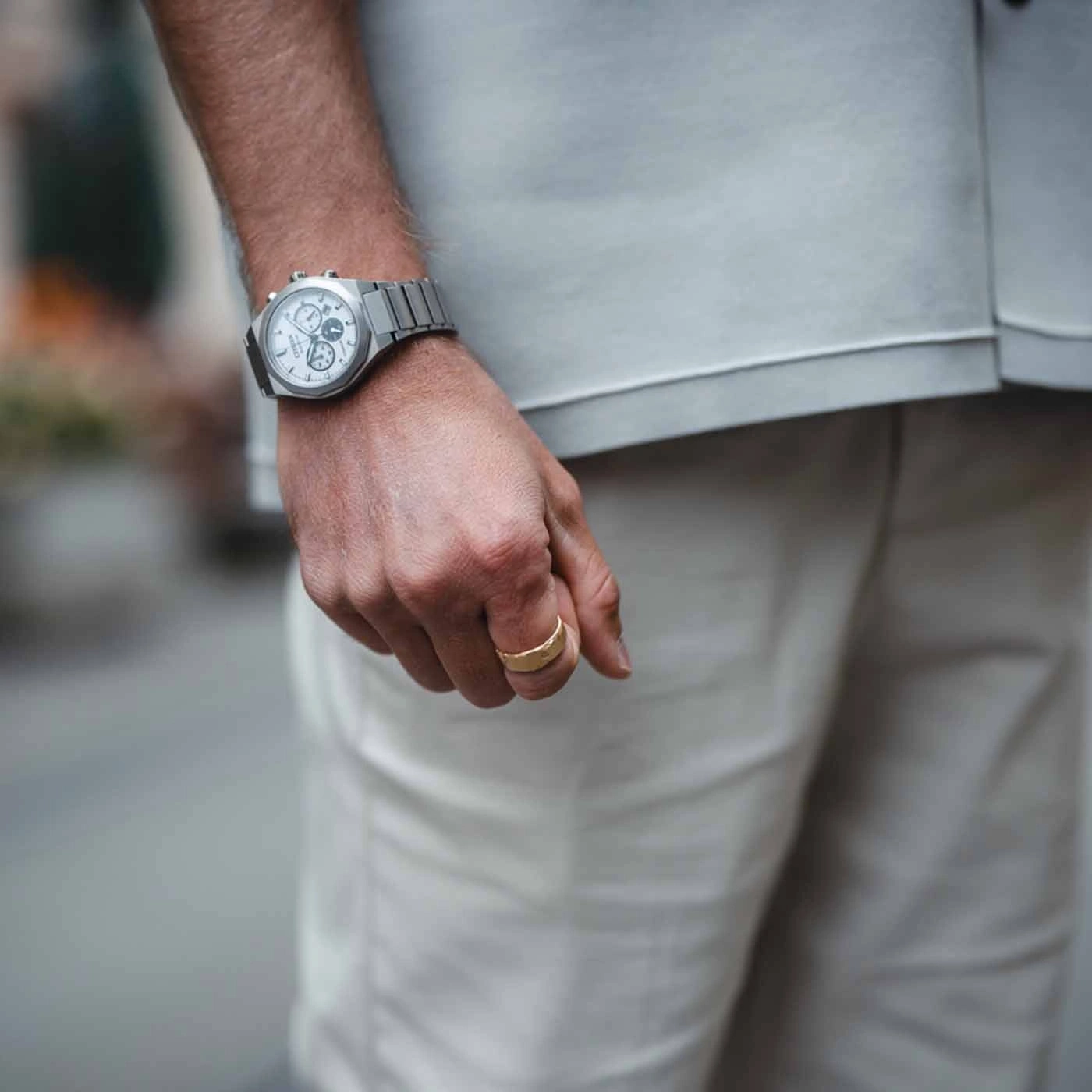Man wearing a watch and a gold ring, close-up shot of his hand.